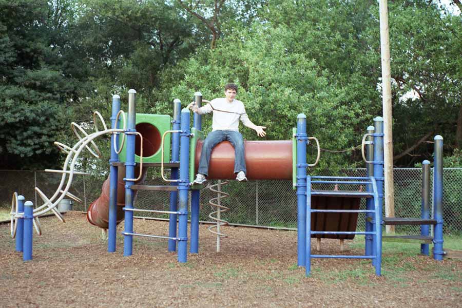 A boy sitting on top of a playground