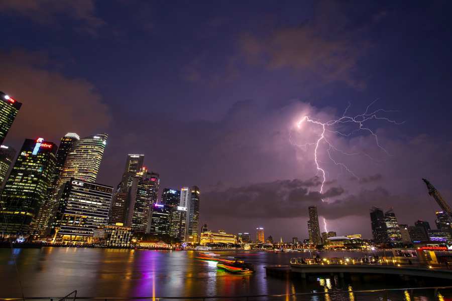 Dramatic shot of lightning striking a building in a city at night