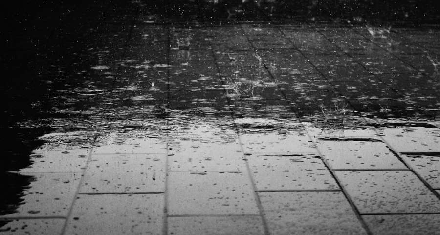 Inclement weather illustrated through rain drops hitting a brick floor