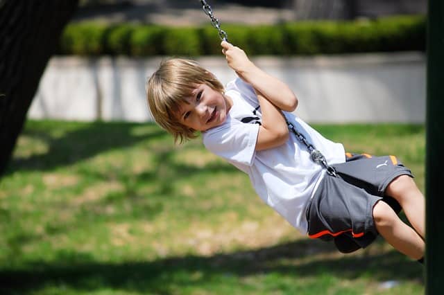 Young child enjoying a playground swing