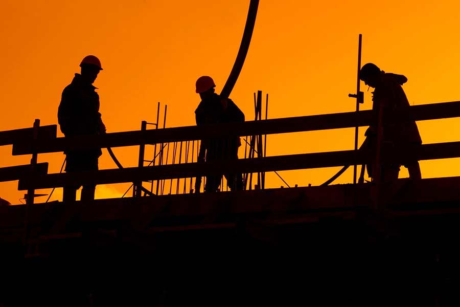 Construction workers silhouetted by the summer sun