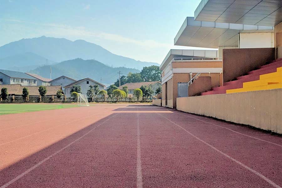 A newly renovated school track with nearby neighborhood homes in the distance