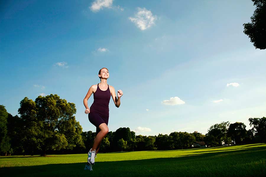 A woman jogging on a park trail near Austin playground services