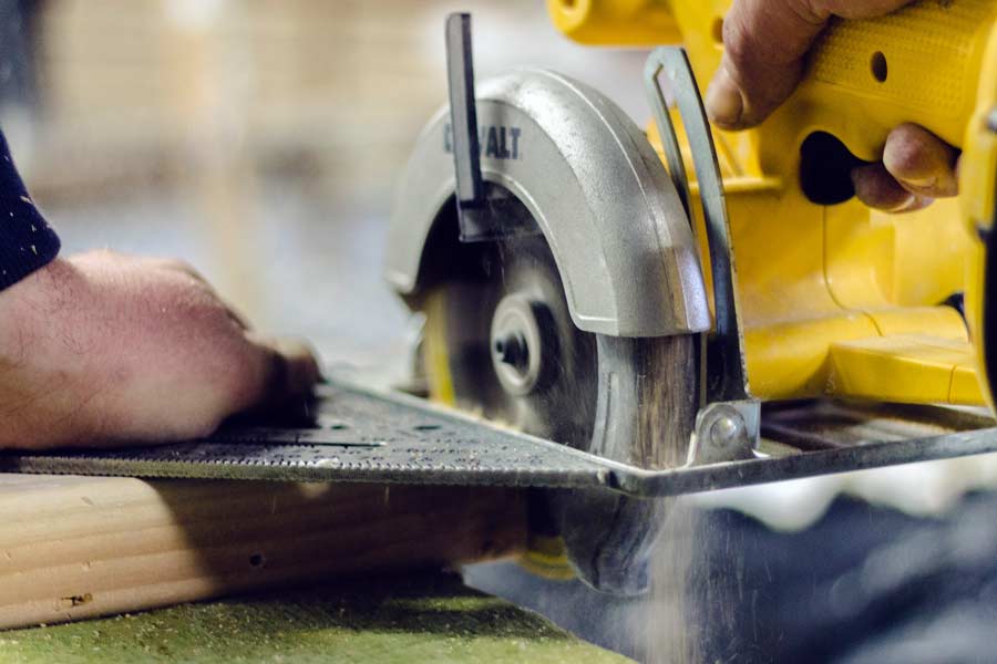 Construction workers using a circular saw