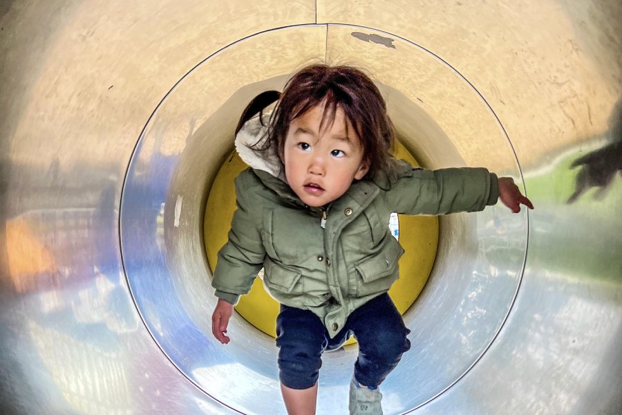 child walking through a tunnel on a playground