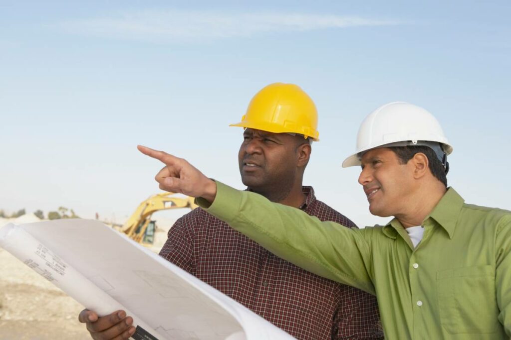 Project manager going over blueprints with a construction worker on a job site