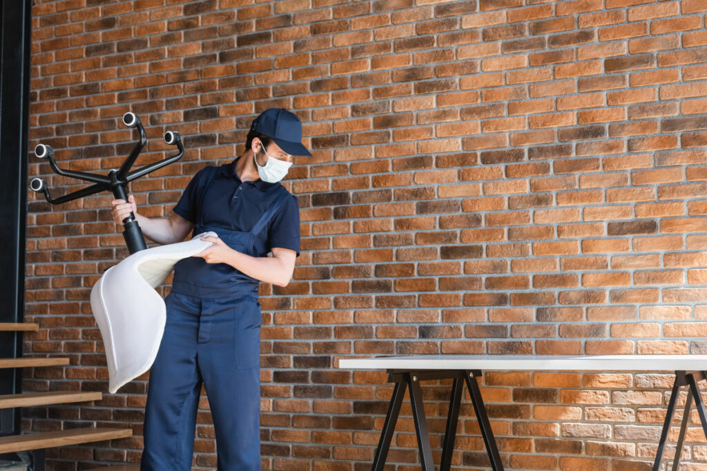 Worker removing a desk chair from an office to prepare for renovation