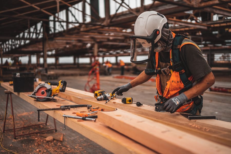 An image of a construction worker using all the safety guidance and work compliance to manipulate his tool with no harm at all