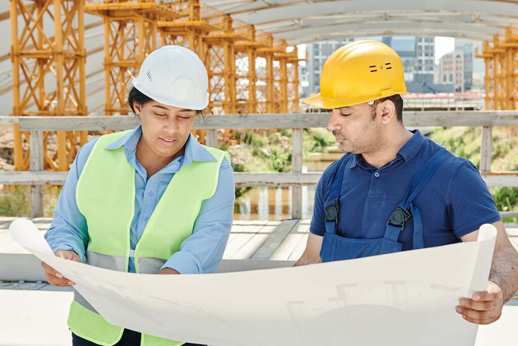 Two construction project managers discuss plans for Austin construction management.