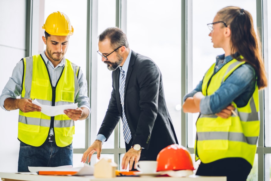 Construction workers discussing plans with a project manager in Austin.