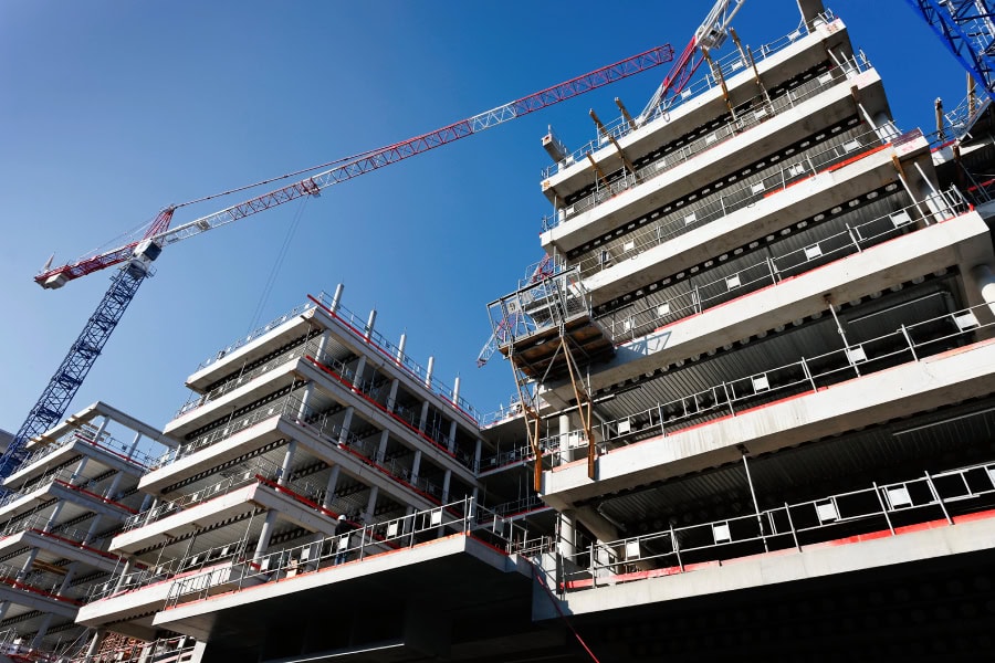 A building with cranes being utilized for new Austin commercial construction projects.