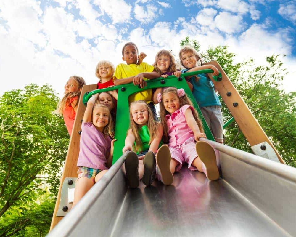 Children Playing Together at the Park Playground Slide