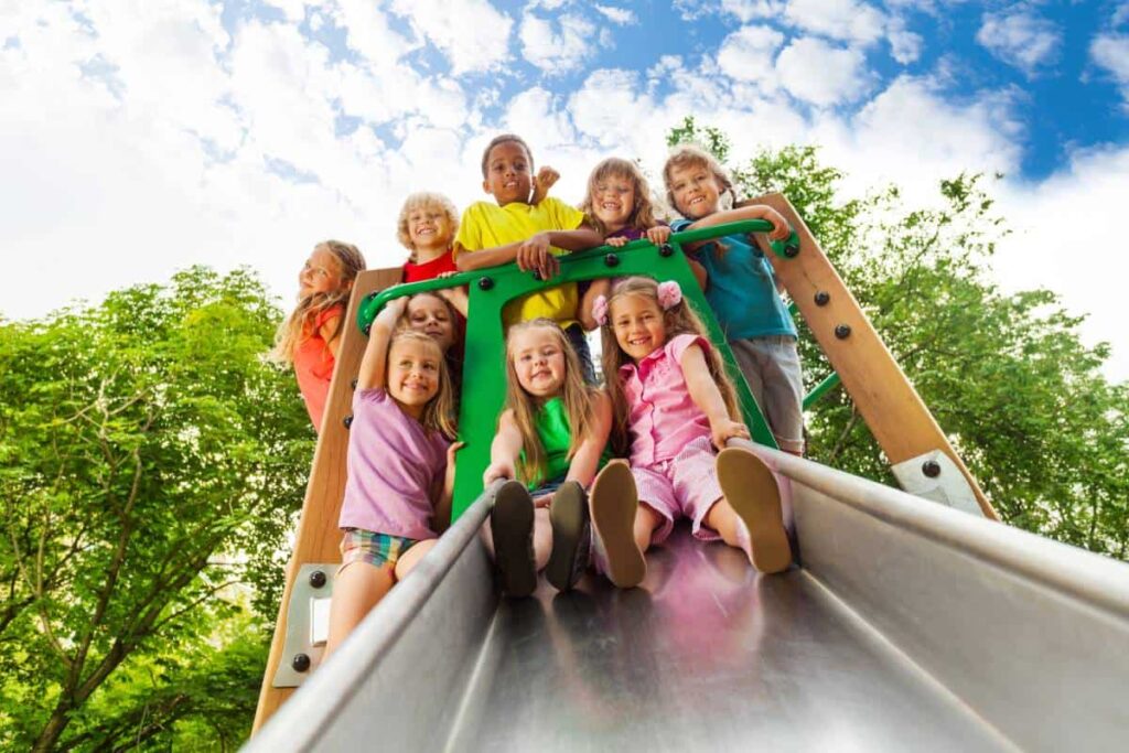 Children Playing Together at the Park Playground Slide