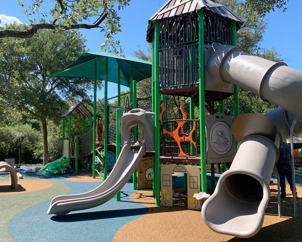 A modern playground is pictured, complete with a safety surface and rainforest theming.