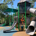 A modern playground is pictured, complete with a safety surface and rainforest theming.