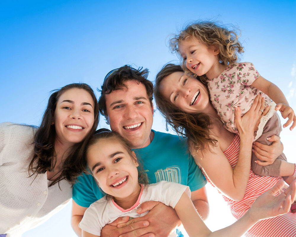 A family smiling after children enjoyed playing on Austin playground equipment.