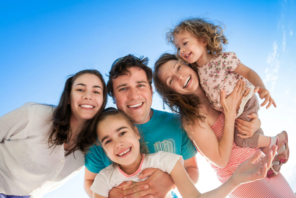A family smiling after children enjoyed playing on Austin playground equipment.