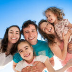 A family smiling after children enjoyed playing on Austin playground equipment.