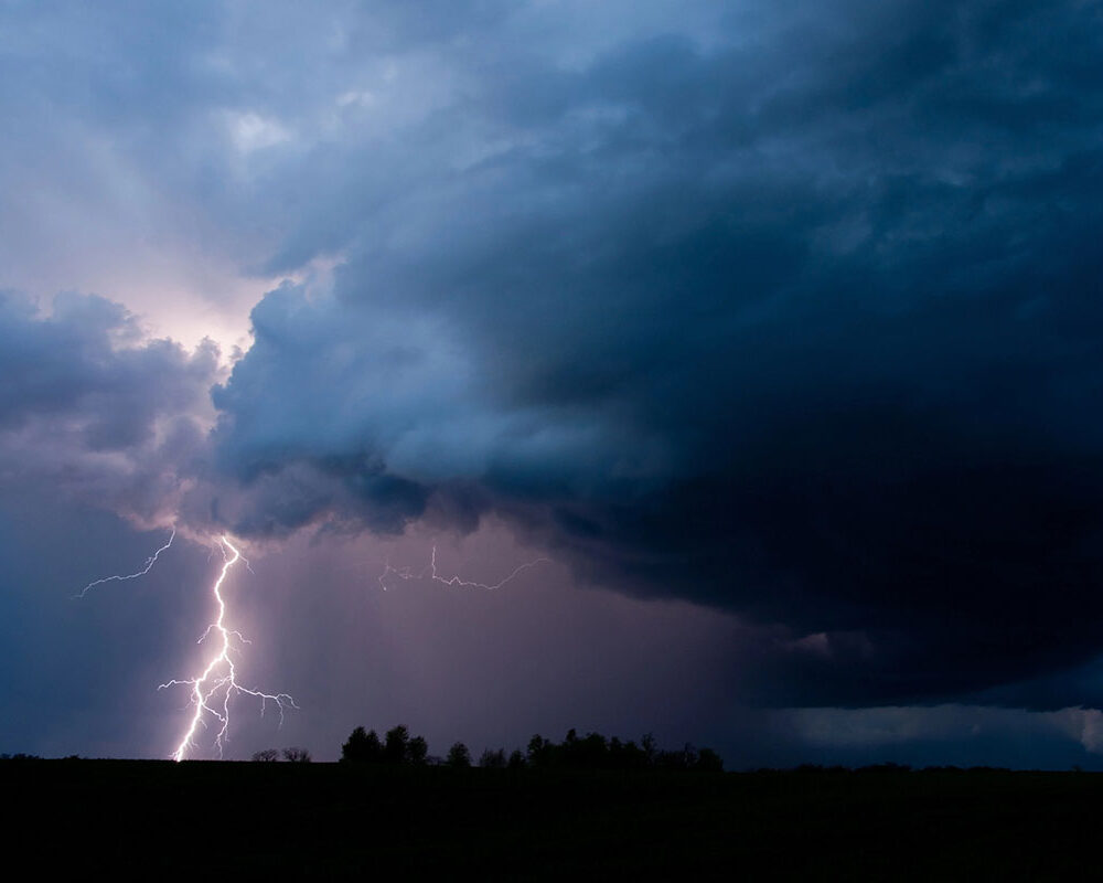 A storm halts Austin construction as lightning strikes under dark clouds.